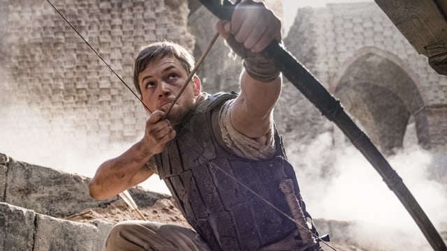 In the picture, Taron Egerton can be seen as stretching a bow with arrows. In the picture, Taron Egerton can be seen as stretching a bow with arrows.