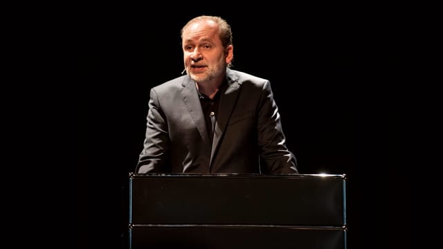 Autor Ferdinand von Schirach bei einer Lesung am Pult. Autor Ferdinand von Schirach bei einer Lesung am Pult.