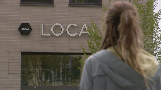 Eine Frau vor dem Local Logo Eine Frau vor dem Local Logo