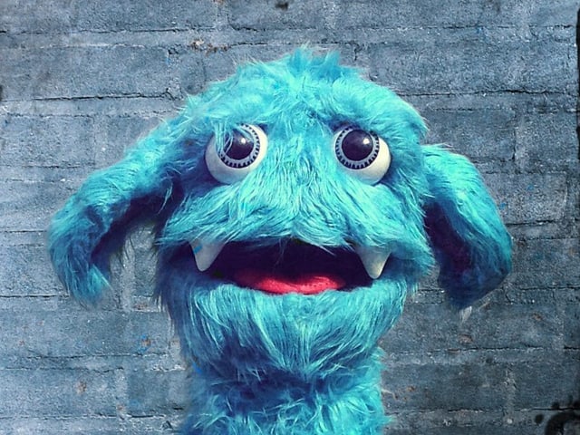Eine blaue, zottelige Puppe mit grossen Augen. Eine blaue, zottelige Puppe mit grossen Augen.