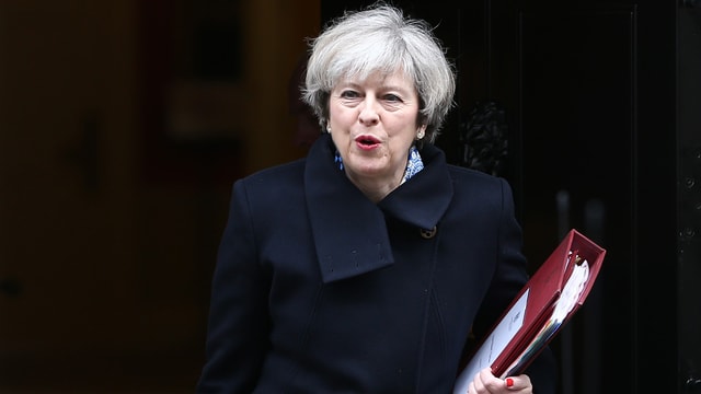 Theresa May mit einem Ordner in der Hand vor schwarzem Hintergrund. Theresa May mit einem Ordner in der Hand vor schwarzem Hintergrund.