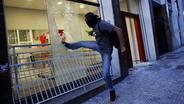Vermummter tritt Bank-Schaufenster ein. Vermummter tritt Bank-Schaufenster ein.