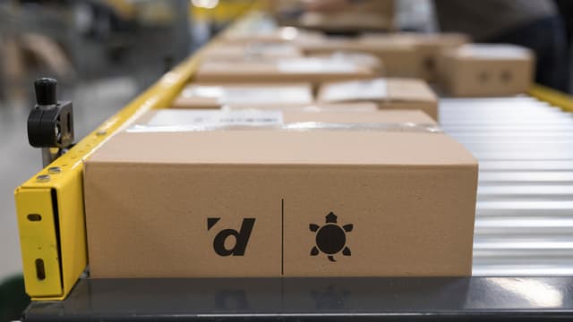 Paket von Galaxus liegt zum Versand bereit auf einem Förderband. Paket von Galaxus liegt zum Versand bereit auf einem Förderband.