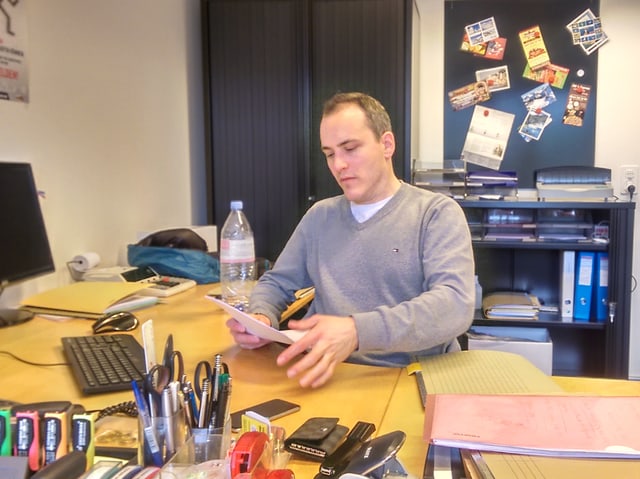 Ein Mann sitzt an einem Schreibtisch Ein Mann sitzt an einem Schreibtisch