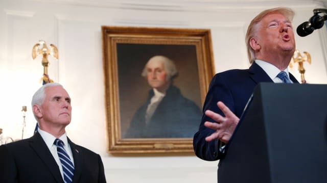 Pence steht hinter Trump, der in ein Mikrofon spricht. Pence steht hinter Trump, der in ein Mikrofon spricht.
