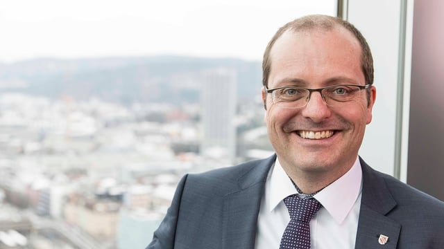 Mann im Anzug vor grossem Fenster Mann im Anzug vor grossem Fenster