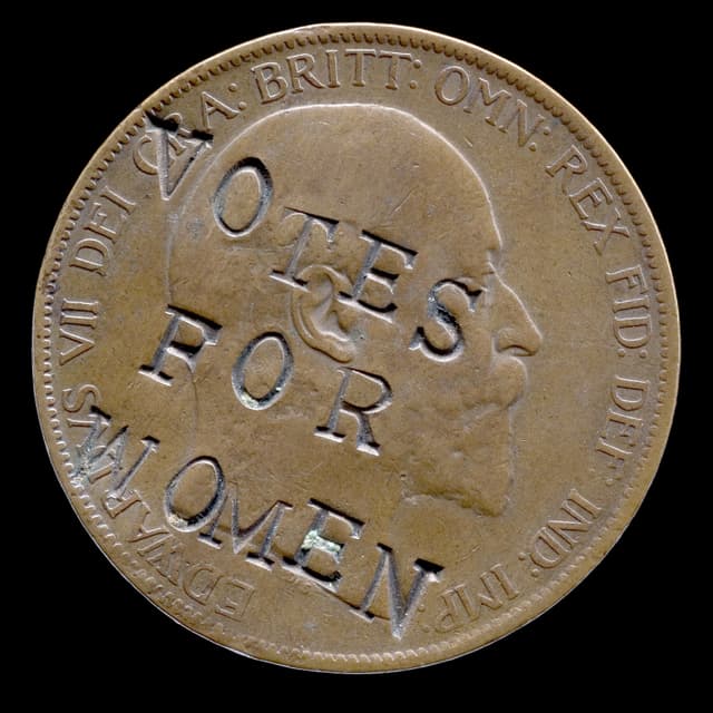 Eine Münze, auf die der Slogan Votes for Women eingebrannt wurde. Eine Münze, auf die der Slogan Votes for Women eingebrannt wurde.