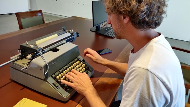 Mann an einer Schreibmaschine Mann an einer Schreibmaschine