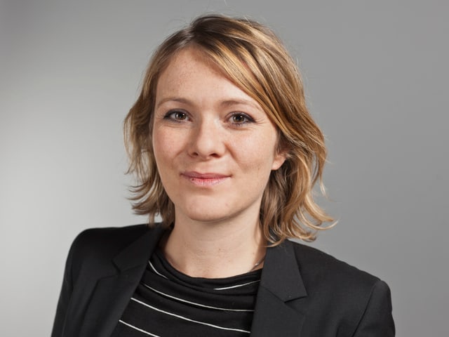 Mit dunklem Blazer und Pullover, blondes Haar, ein Lächeln. Mit dunklem Blazer und Pullover, blondes Haar, ein Lächeln.