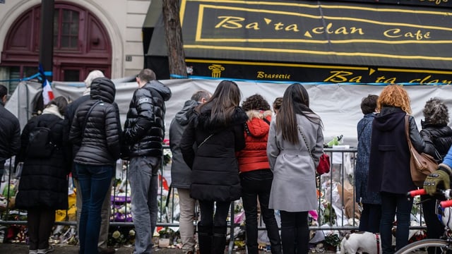 Menschen stehen vor dem Konzertsaal Bataclan, wo Blumen niedergelgt wurden. Menschen stehen vor dem Konzertsaal Bataclan, wo Blumen niedergelgt wurden.