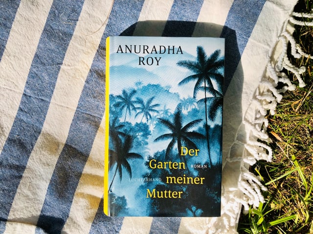 Der Roman «Der Garten meiner Mutter» von Anuradha Roy liegt auf indischem Tuch Der Roman «Der Garten meiner Mutter» von Anuradha Roy liegt auf indischem Tuch