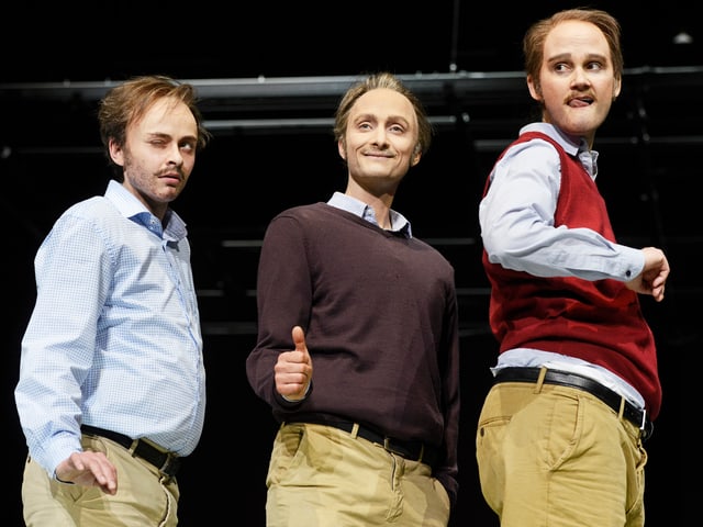 Drei Schauspielerinen in Männerkleidern posieren lachend auf einer Bühne. Drei Schauspielerinen in Männerkleidern posieren lachend auf einer Bühne.