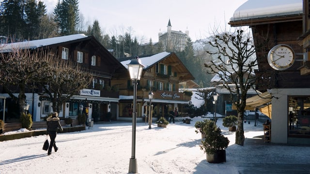 Eine Frau geht durch das winterliche Gstaad Eine Frau geht durch das winterliche Gstaad