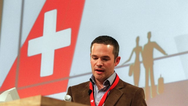 Ein Mann mit kurzen Haaren steht neben der Heckflosse eines Flugzeugs der Swiss. Ein Mann mit kurzen Haaren steht neben der Heckflosse eines Flugzeugs der Swiss.