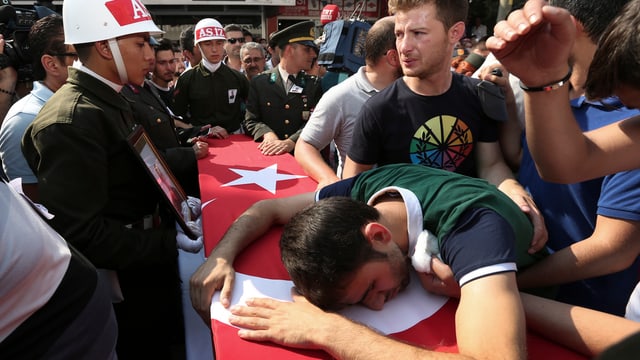 Mann liegt auf einem Sarg mit türkischer Flagge Mann liegt auf einem Sarg mit türkischer Flagge