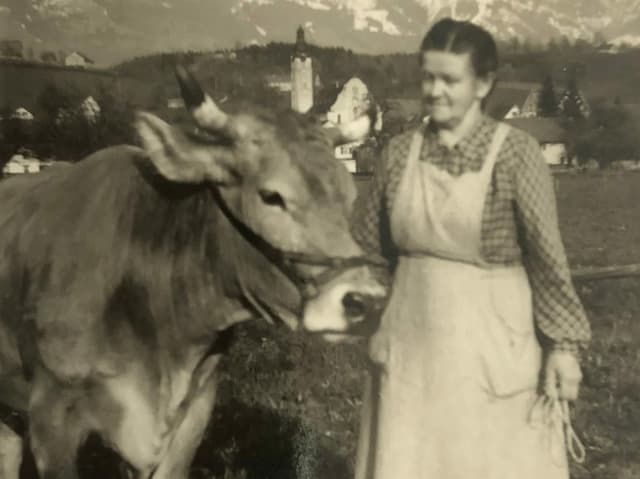 Frau mit Kuh auf einem alten Foto. 