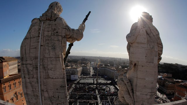Blick auf den Petersplatz: Hinter zwei grossen Steinstatuen ist die Masse zu sehen, die sich zur Inauguration des neuen Papstes Franziskus eingefunden hat. Blick auf den Petersplatz: Hinter zwei grossen Steinstatuen ist die Masse zu sehen, die sich zur Inauguration des neuen Papstes Franziskus eingefunden hat.