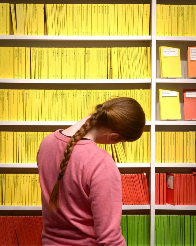 Eine Studentin vor einem Buchregal mit Reclams. Eine Studentin vor einem Buchregal mit Reclams.