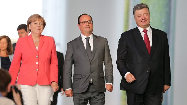 Merkel, Hollande und Poroschenko schreiten nebeneinander zur Medienkonferenz. Merkel, Hollande und Poroschenko schreiten nebeneinander zur Medienkonferenz.