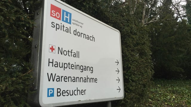 Schild mit Wegweisern zu Notfall und Haupteingang beim Spital Dornach Schild mit Wegweisern zu Notfall und Haupteingang beim Spital Dornach