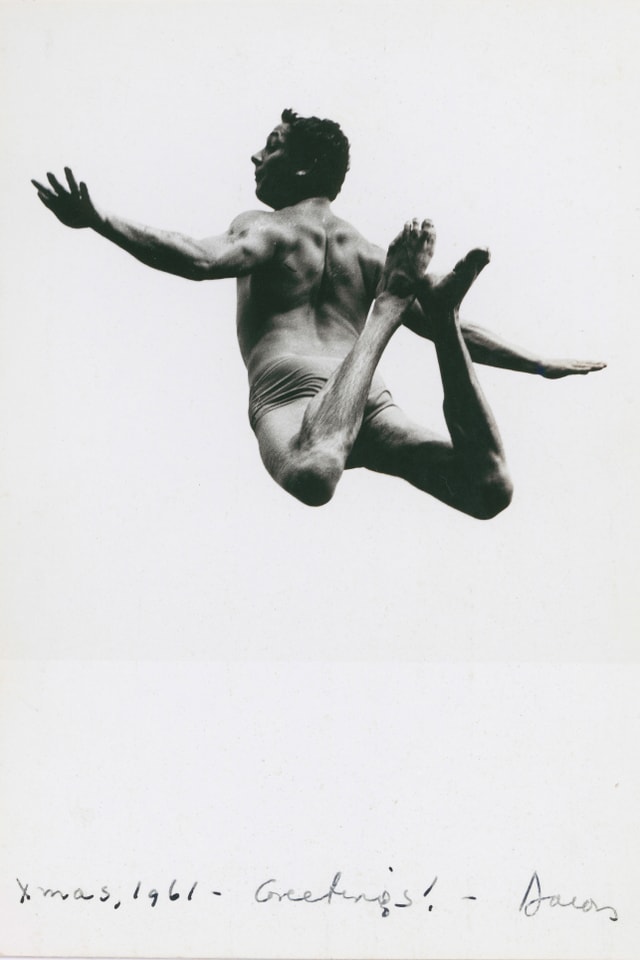 Ein Mann in Badehose springt in der Luft.