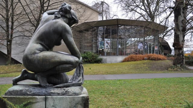 Bronzefigur vor Glaspavillon Bronzefigur vor Glaspavillon
