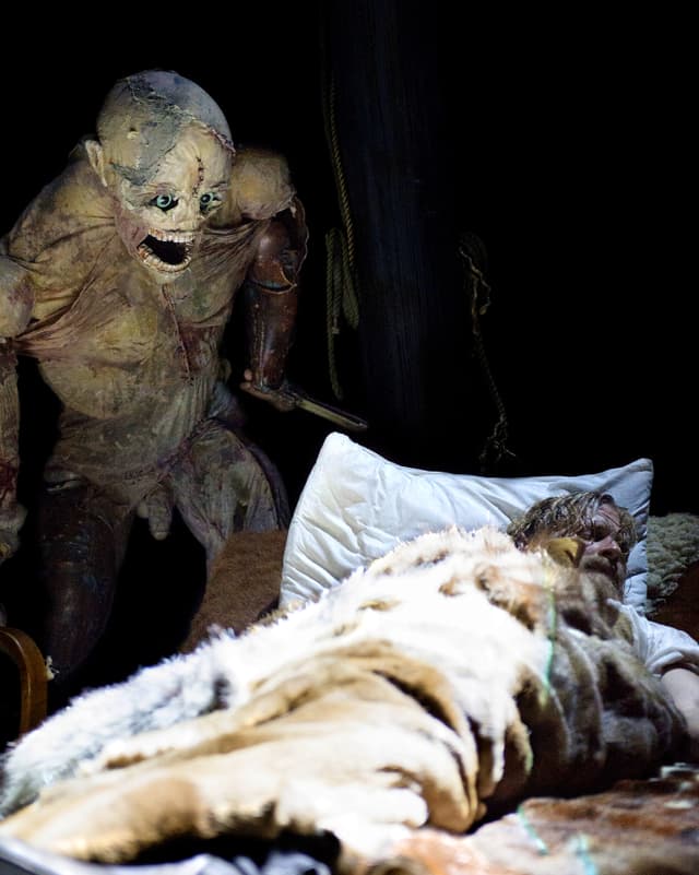 Monster-Puppe schleicht sich mit Messer in der Hand an schlafenden Mann heran. Monster-Puppe schleicht sich mit Messer in der Hand an schlafenden Mann heran.