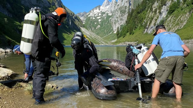 Taucher und Helfer stehen mit Gerätschaften im Fählensee Taucher und Helfer stehen mit Gerätschaften im Fählensee