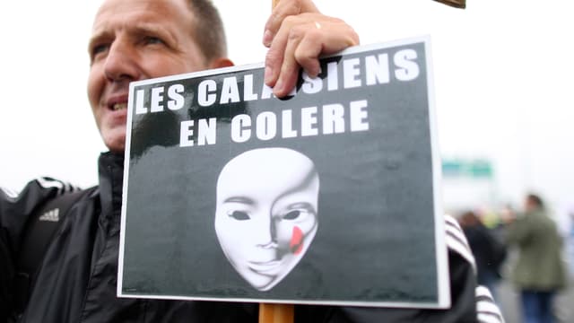 Demonstrant in Calais, Schild mit der Aufschrift: «Die Bewohner von Calais sind wütend»