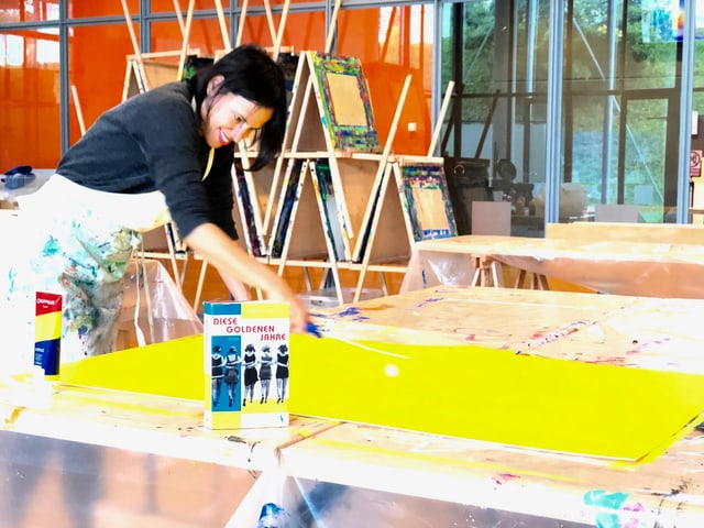 Annette König bepinselt ein grosse Leinwand in einem Atelier. Annette König bepinselt ein grosse Leinwand in einem Atelier.