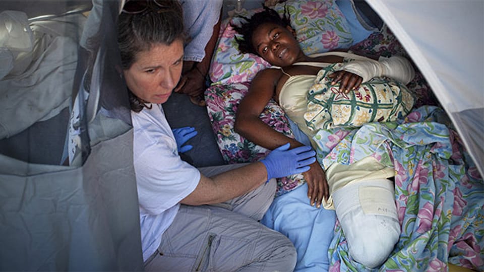 Mitarbeiter von Handicap International betreuen eine am Bein amputierte Haitianerin.