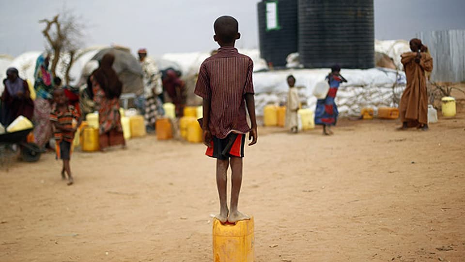 Ausserhalb vom Flüchtlingscamp in Dadaab: Ein Kind aus Somalien wartet darauf, eine Ration Wasser zu erhalten.