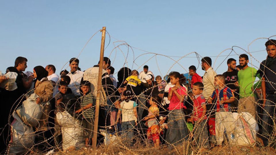 Flüchtlinge an der syrisch-türkischen Grenze in Hatay (Türkei) warten darauf, sich registrieren zu können.