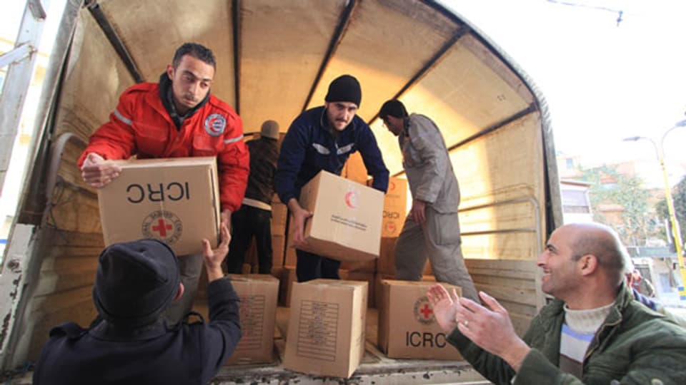 Mitarbeiter des Syrischen Roten Halbmondes beim Verteilen von Hilfsgütern.