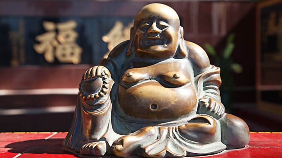 Einer Buddha-Figur über den Bauch zu streichen soll Glück bringen.