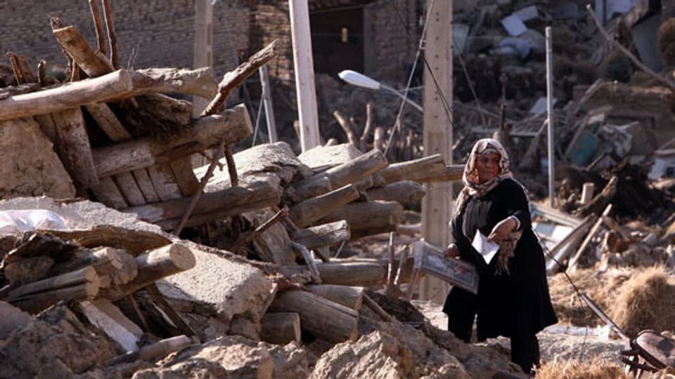 Am 12. August 2012 erschütterten zwei starke Erdbeben den Nord-Westen vom Iran. Iranerin vor ihrem zerstörten Haus in Varzaqan.