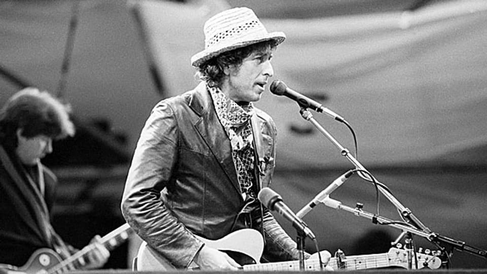 Das ist Robert Allen Zimmerman bei einem Auftritt in Basel, 1984. Bekannt ist er allerdings unter dem Namen Bob Dylan.