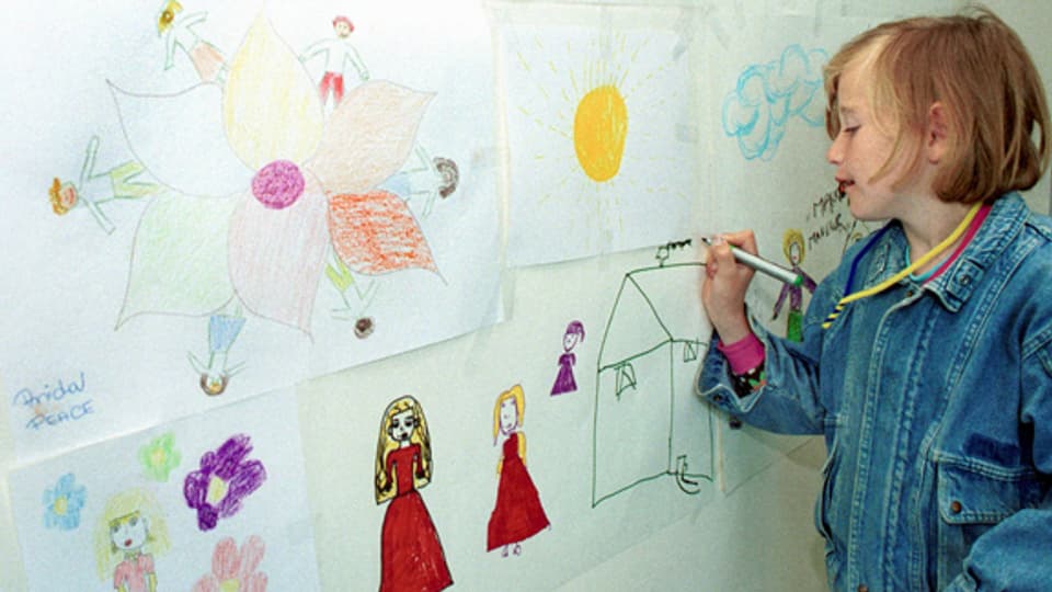 Mirela malt in einer Therapiestunde ihre Erfahrungen an die Wand.