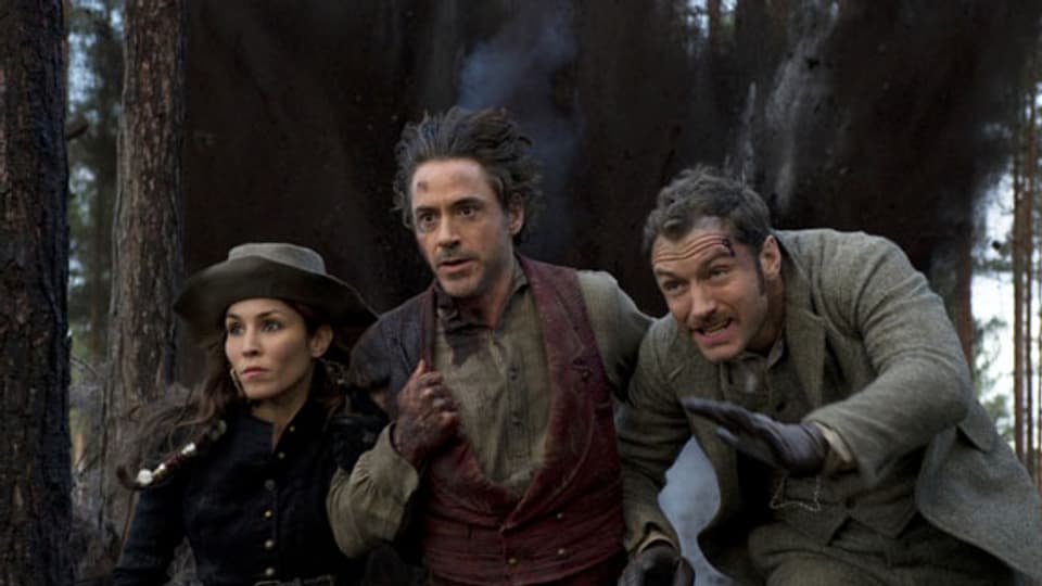Sherlock Holmes (Robert Downey Jr., Mitte) reitet seinen Freund Dr. Watson (Jude Law) und die Wahrsagerin Sim (Noomi Rapace) in Schwierigkeiten.