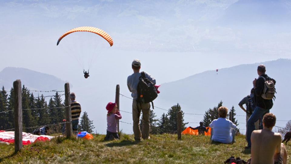 Paraglider starten auf der Rigi und fliegen hinab in Richtung Luzerner See.