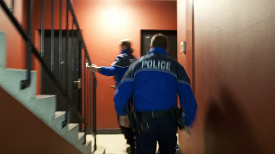 Zwei Lausanner Polizisten bei einer Hausdurchsuchung.