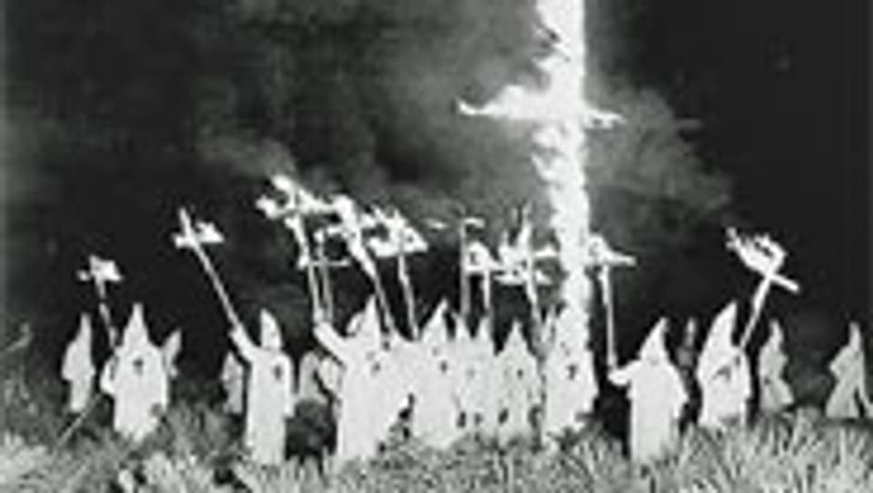 Das brennende Kreuz und weisse, spitze Kapuzen sind die markanten Symbole des Klans (Aufnahme aus dem Jahr 1922).