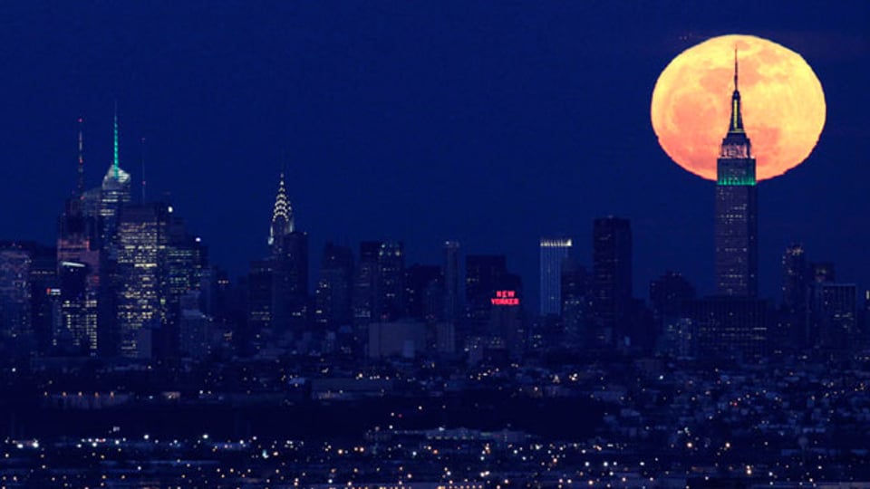 «Die Stadt, die niemals schläft»: Der Mond steht hinter dem Empire State Building, New York.