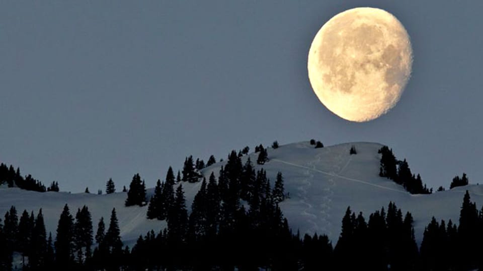 Der abnehmende Mond senkt sich hinter der Zweierspitze oberhalb Untervaz im Churer Rheintal.
