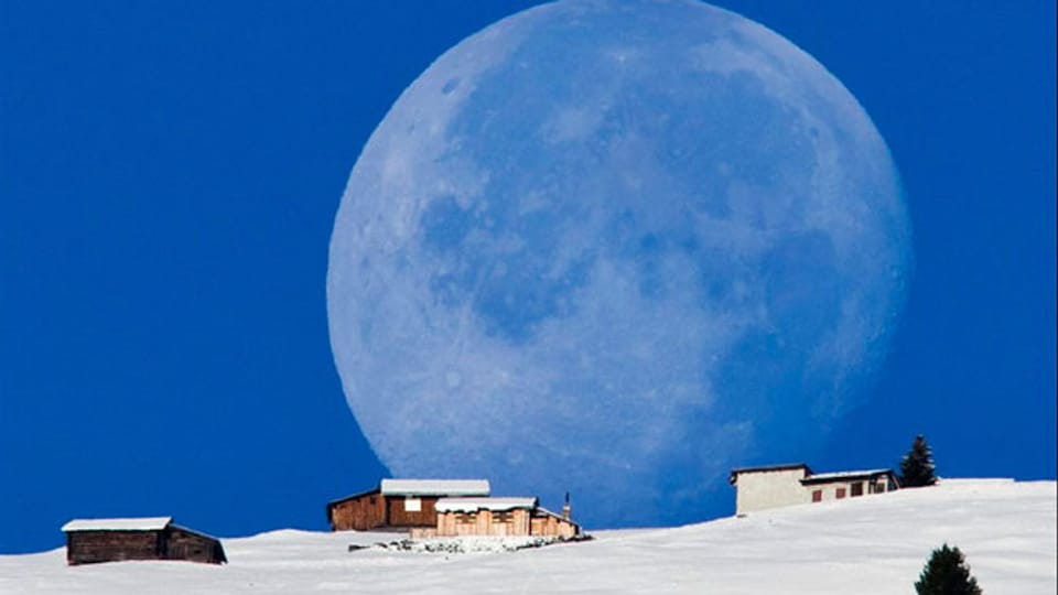 Der abnehmende Mond senkt sich über die Alp Salaz, Graubünden.