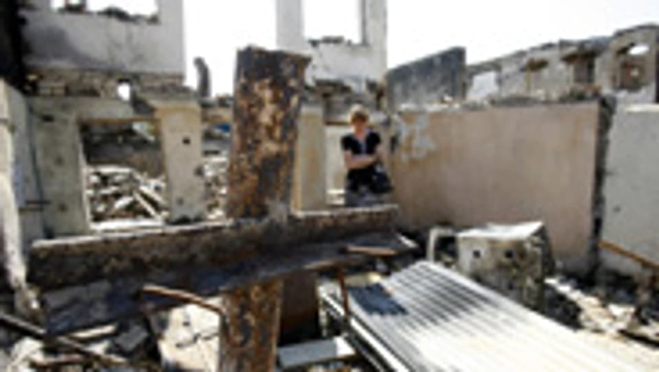 Eine Frau steht in den Trümmern ihres Hauses in Zchinwali, Hauptstadt von Ossetien.