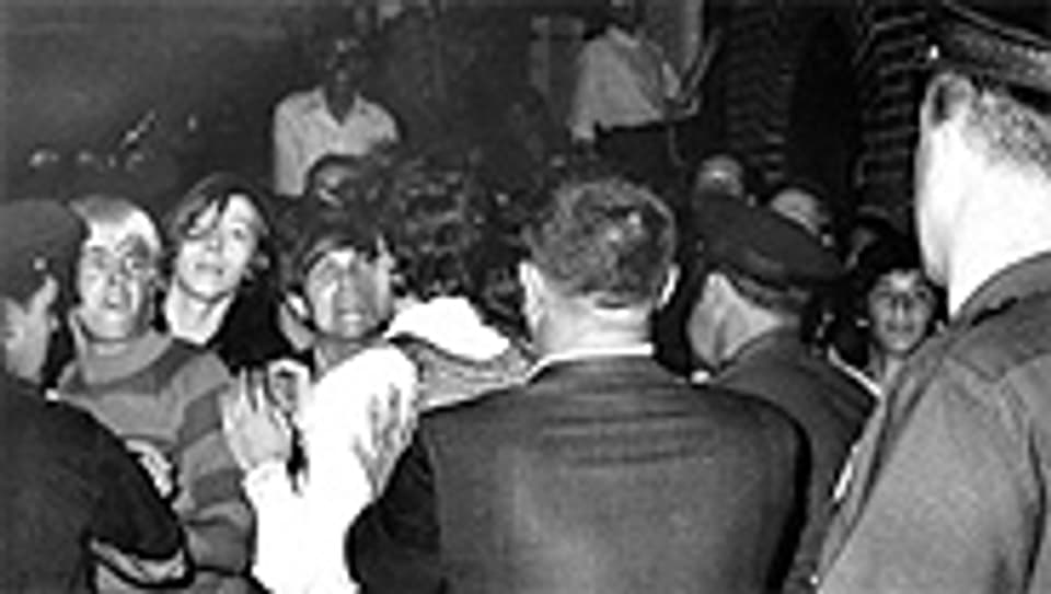 Menschen versuchen die Polizei vor dem Eindringen in den Stonewall Club zu stoppen, New York 1969.