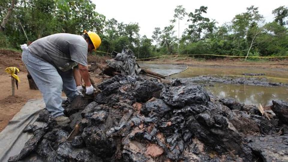 Ein ecuadorianischer Arbeiter beseitigt Ölverschmutzungen.
