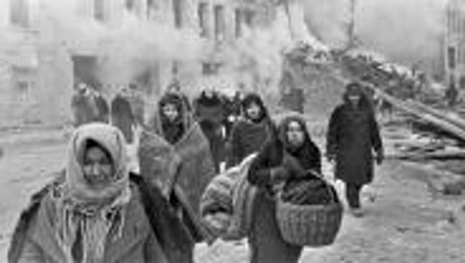 Bewohner Leningrads verlassen ihre zerstörten Häuser.
