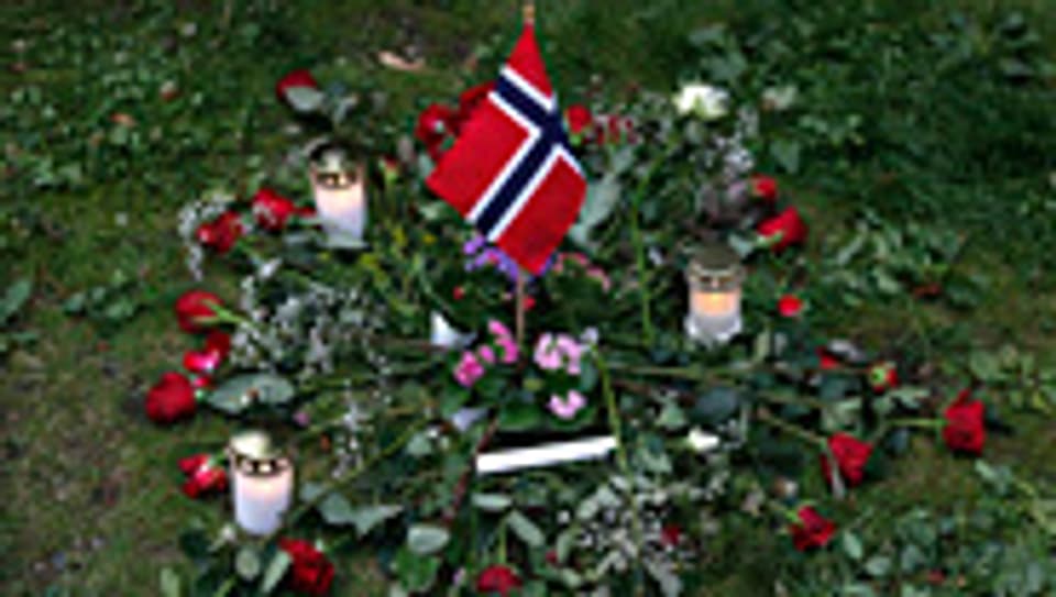 Blumen und Kerzen in der Nähe des zerstörten Regierungsgebäudes in Oslo.